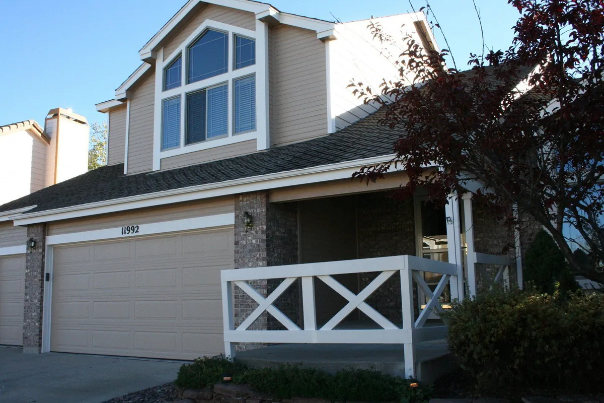 Repainted two-story home with brick wainscot and stone columns