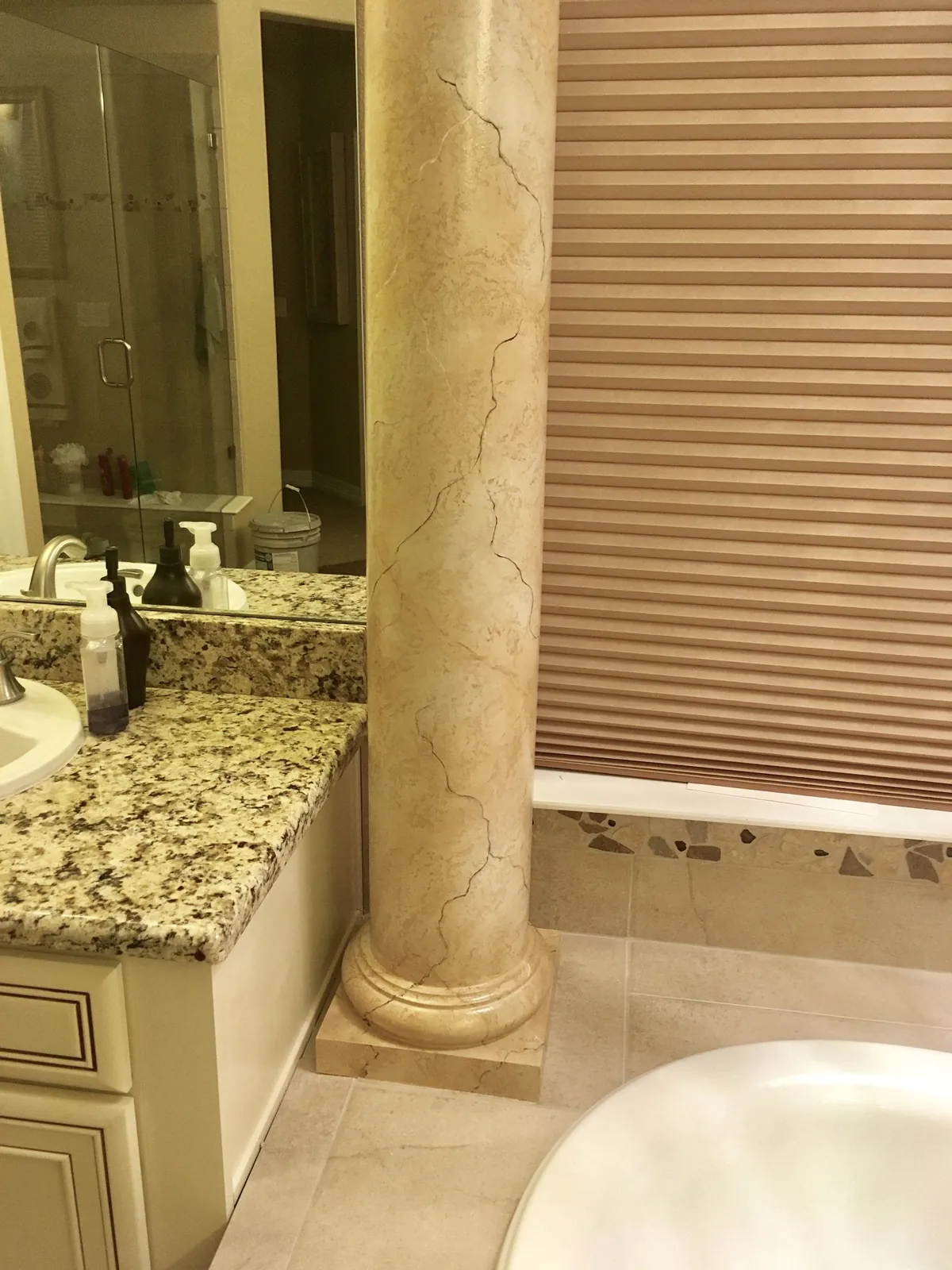 Faux marble column beside a garden tub