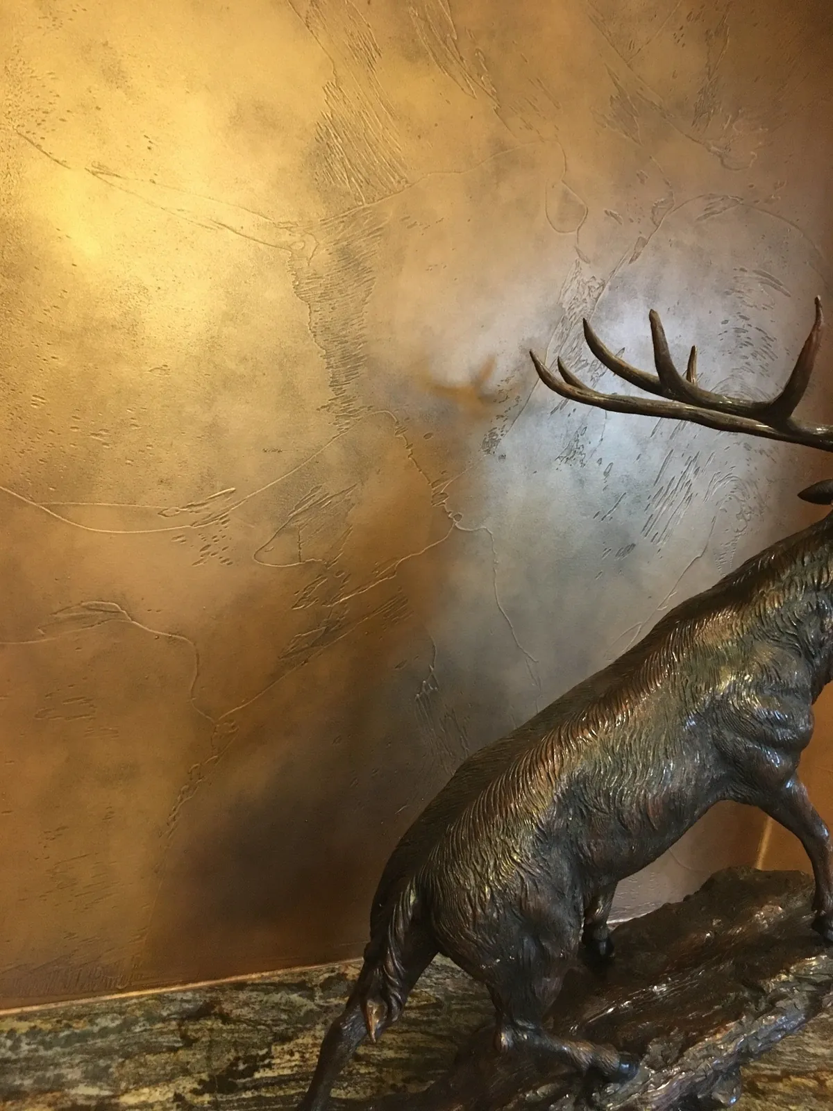 Metallic glaze detail behind a bronze elk