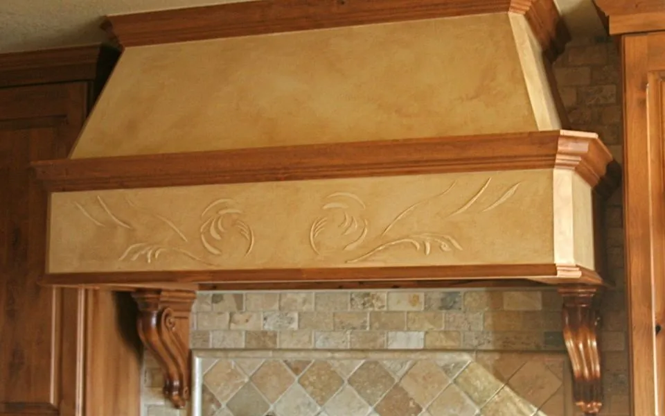 Faux-finished range hood with carved trim