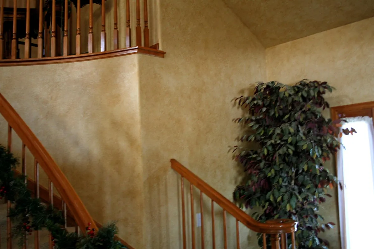 Patina faux finish rising along a two-story staircase