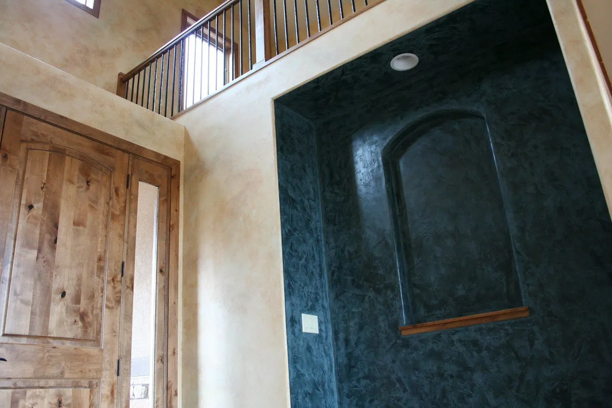 Deep green Venetian plaster niche in an entry with knotty alder doors